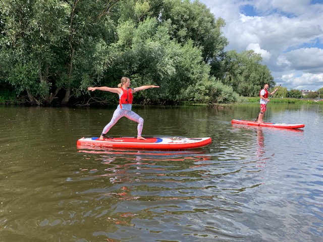 Paddleboard yoga at calm yoga sup school