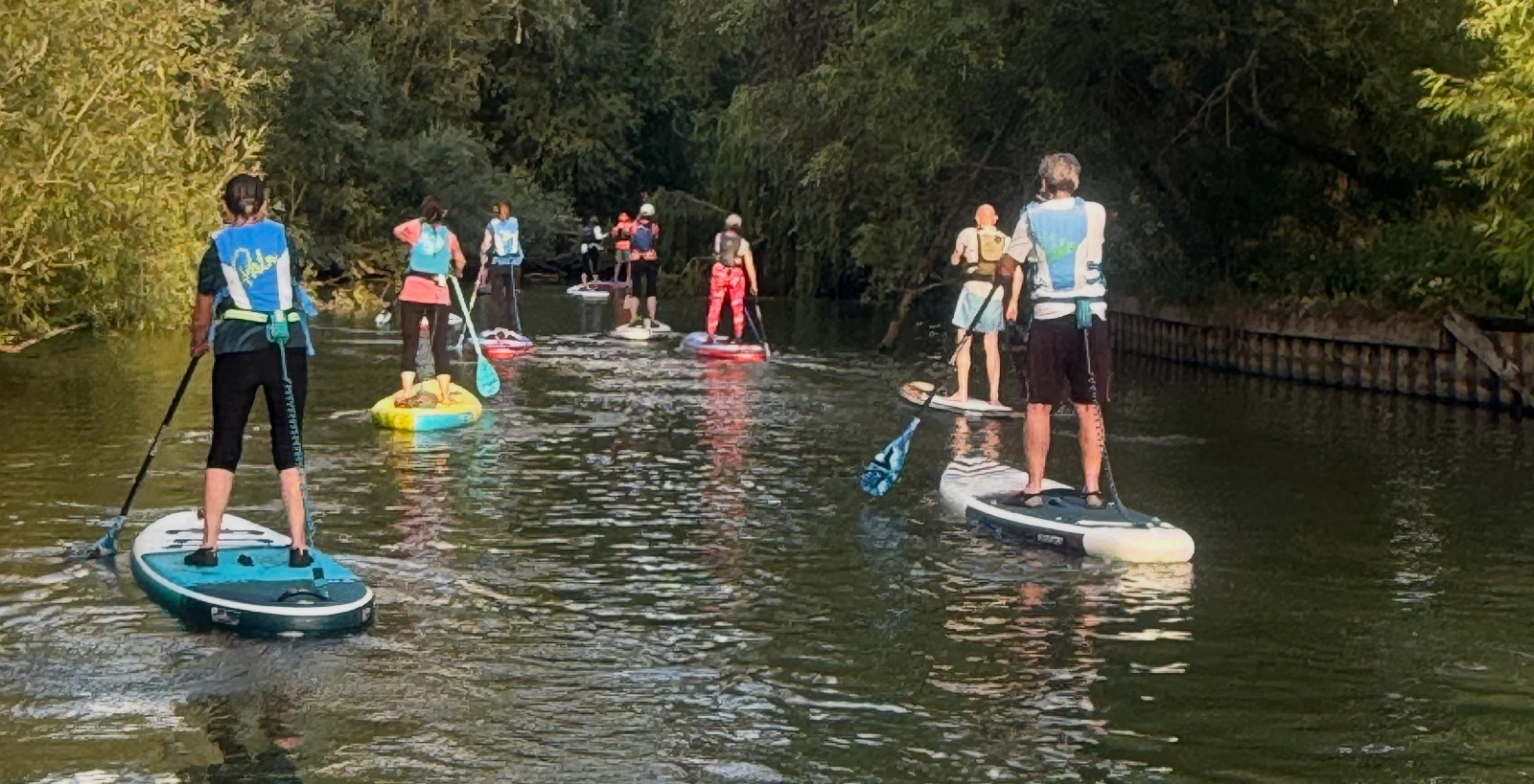 A group of stand up paddleboarders paddling a section of the UK's canal and river network.